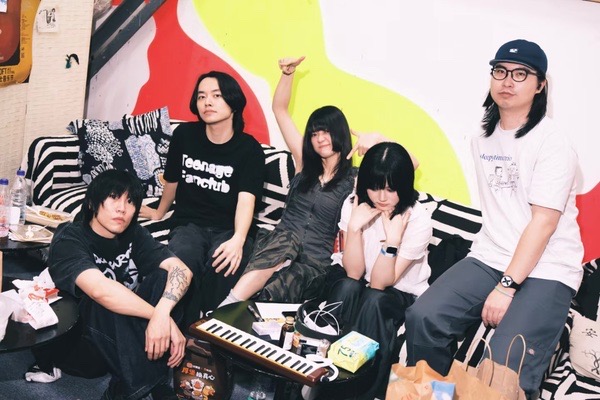 The five members of The Three Mice sitting backstage at a live house